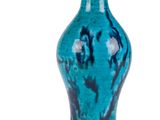 un vase bleu posé sur une surface blanche