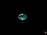 a close up of a green sapphire stone on a black surface
