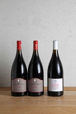 three bottles of wine are lined up on a wooden table