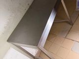 a metal table that is sitting on a tiled floor