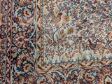 an antique persian rug with a floral design on a blue ground