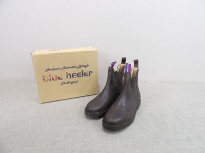 Les bottes marron se trouvent à côté d'une boîte posée sur la table.