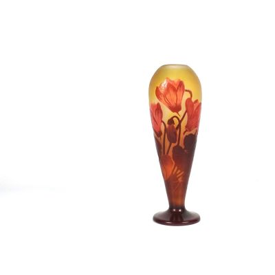 un vase en verre sur lequel sont peintes des fleurs sur un fond blanc