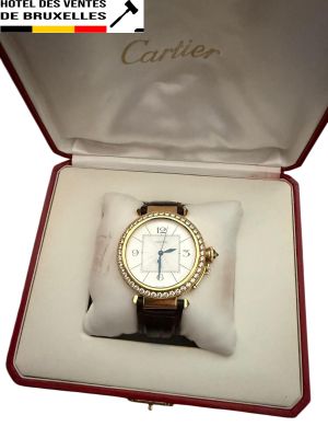 une montre dans un coffret ouvert, posée sur une surface blanche