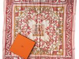 a square scarf with an orange box on top of it