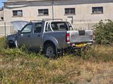 a truck that is parked in the grass by a building