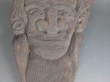 une sculpture en argile représentant un homme barbu coiffé d'un chapeau