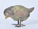 a small bird that is standing on a metal stand