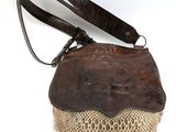an old purse with a lace and leather handle on a white background