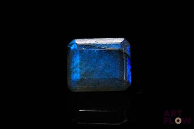 a close up of a blue stone on a black surface