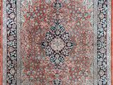 a red and black rug with a medallion design on it