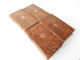 two brown leather cases with gold buttons on them on a white surface