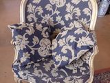 a blue and white chair with pillows on it in a room