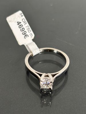 a close up of a diamond ring on a table with a price tag