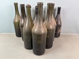 plusieurs bouteilles de vin vides alignées en rang sur une table