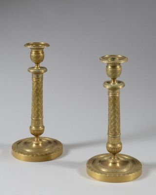 pair of antique brass candlesticks on a white background