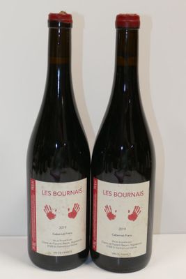 deux bouteilles de vin posées sur une table l'une à côté de l'autre