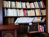 a bookshelf filled with many books in a room