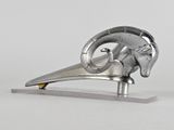 une sculpture métallique représentant une tête de bélier posée sur un socle