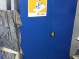 un casier bleu sur lequel est posé un sac et sur la porte duquel est accrochée une pancarte