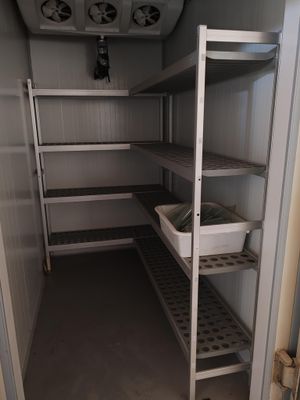 un petit cellier équipé d'étagères et de bacs