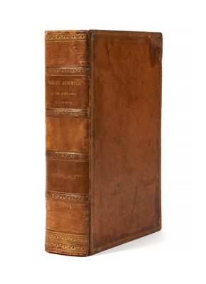 un vieux livre à la couverture en cuir marron posé sur une surface blanche
