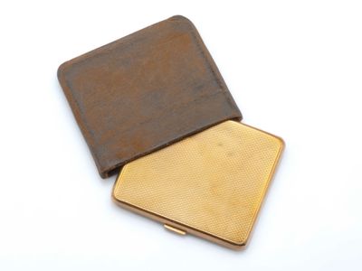 une image représentant une petite boîte en métal recouverte de cuir marron
