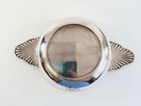 a silver plate with a mirror in it on the wall