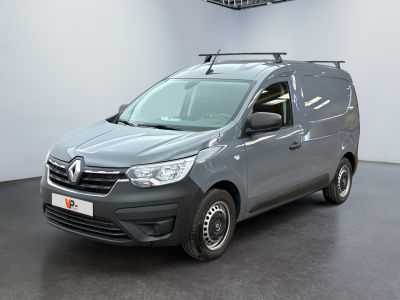 La camionnette grise est garée dans une pièce blanche au sol noir.