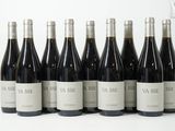six bouteilles de vin sont alignées sur une table