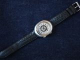 a close up of a wrist watch on a blue surface