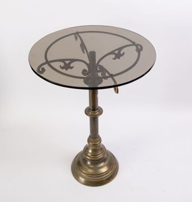 une table en verre sur laquelle est posée une horloge, sur fond blanc