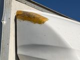 an image of a white refrigerator with a rusted door