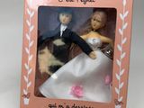 bride and groom figurines in a pink box for a wedding gift
