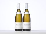 two bottles of white wine sitting on top of a table