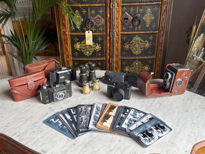 a table with a bunch of old cameras and other items on it