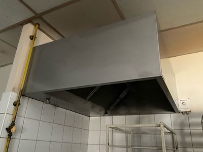 une photo d'une cuisine avec une cuisinière et une hotte murale