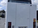 a white bus that is parked on the side of the road