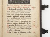 un vieux livre sur lequel figurent des inscriptions en noir et rouge