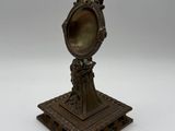 an antique bronze figurine of a woman holding a mirror