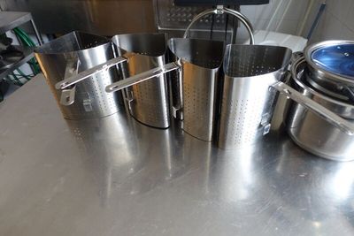 plusieurs casseroles et poêles posées sur une table dans une cuisine