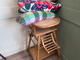 brightly colored pillows on a stool in a corner of a room