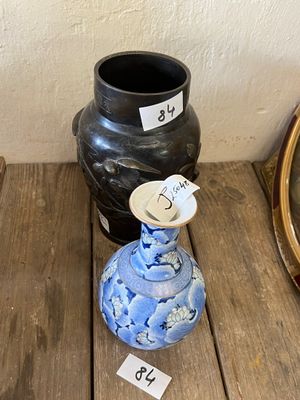 deux vases posés sur une table en bois à côté d'un miroir