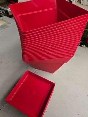 de nombreux récipients en plastique rouge posés sur une table