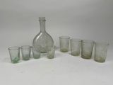 bottles and glasses are lined up on a white surface