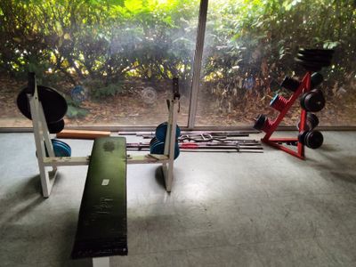 une salle de sport équipée d'un banc, d'haltères et d'appareils de musculation