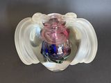 a glass vase with a pink and blue candle inside of it