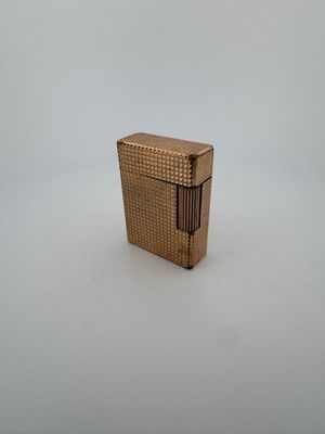 l'image d'un briquet doré posé sur une surface blanche
