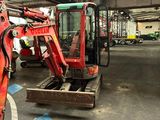 une pelleteuse rouge garée dans un garage