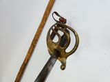 a sword with a handle on a white surface